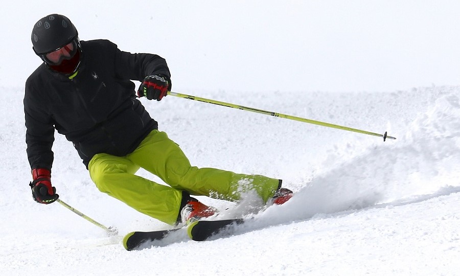 narciarz zjeżdżający z góry po śniegu